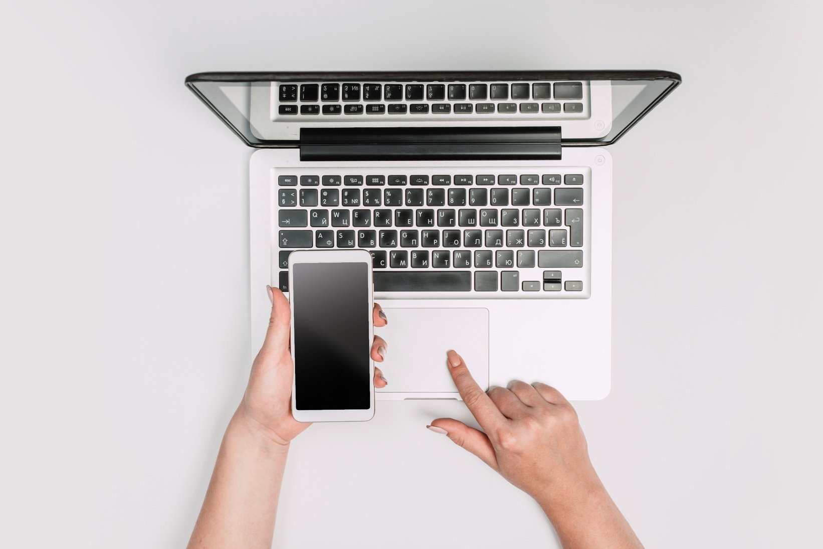 Modern workspace with smartphone and laptop copy space on white color background. Top view.